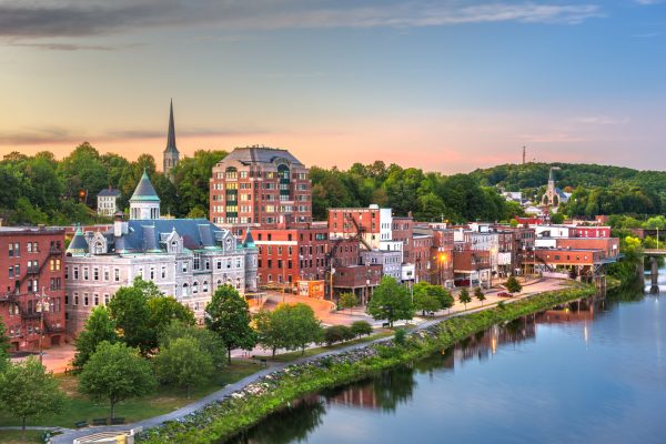 Augusta, Maine, USA town skyline on the Kennebec River at dusk.