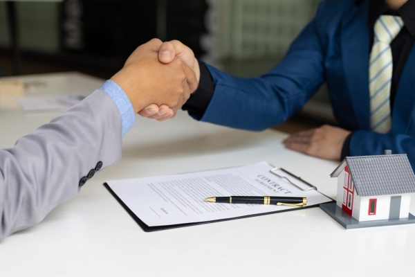 Businessman handshake after reaching a real estate deal. Signing a house rental, mortgage, lease, contract agreement.